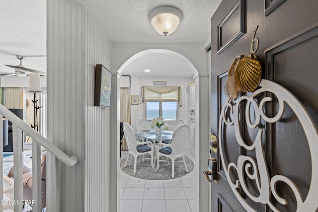 hallway featuring a textured ceiling and light tile patterned floors