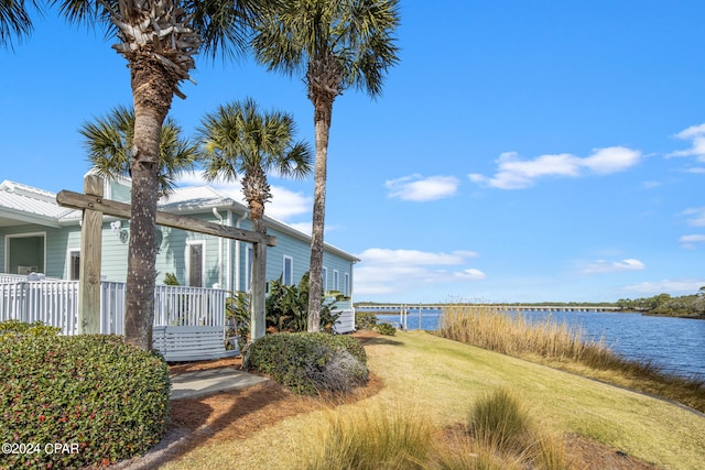 view of side of property with a yard and a water view