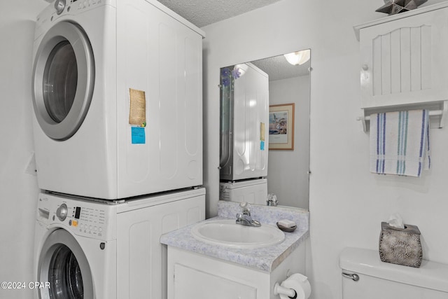 23223 Front Beach Rd Unit Ph-06, Panama City Beach, FL 32413 - bathroom featuring a textured ceiling, stacked washer and clothes dryer, toilet, and vanity