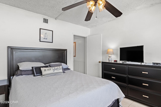 tiled bedroom featuring a textured ceiling and ceiling fan