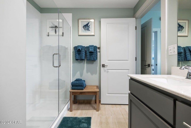 bathroom featuring hardwood / wood-style floors, an enclosed shower, and vanity