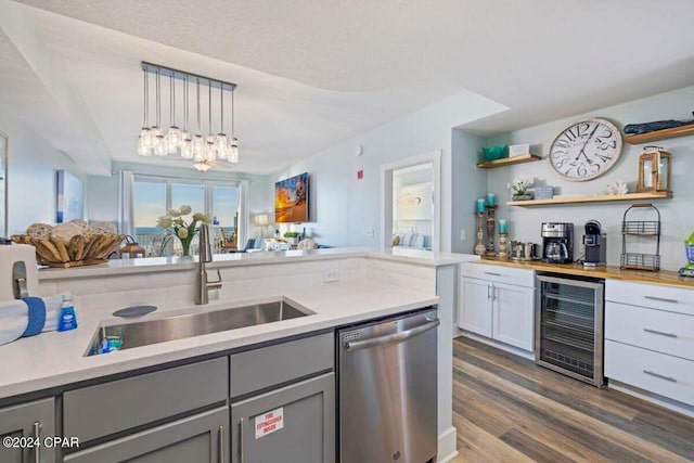 kitchen with hanging light fixtures, dishwasher, sink, dark hardwood / wood-style floors, and beverage cooler