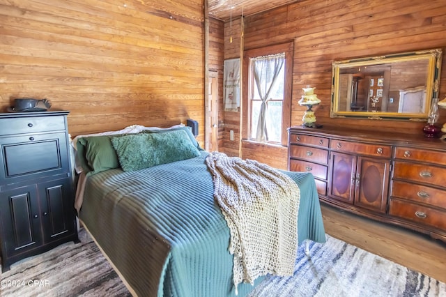 bedroom featuring wood walls and light hardwood / wood-style flooring