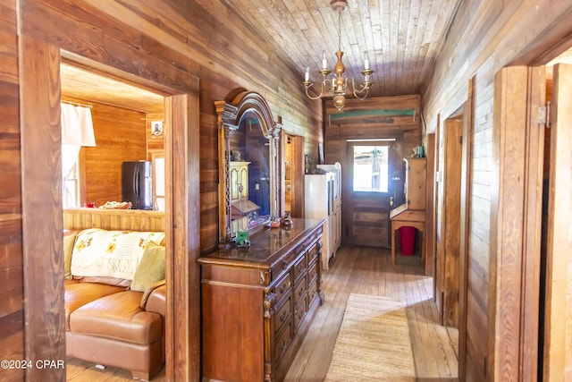 hallway with a chandelier, wooden walls, wooden ceiling, and wood-type flooring