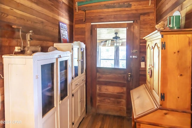 kitchen with white cabinetry, wooden walls, and ceiling fan