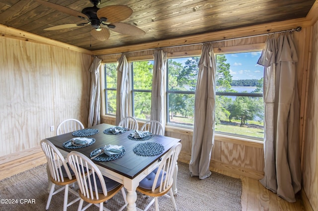 dining area featuring ceiling fan, hardwood / wood-style floors, wooden ceiling, and wood walls