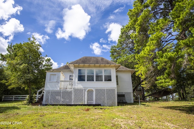 rear view of property with a yard and a wooden deck