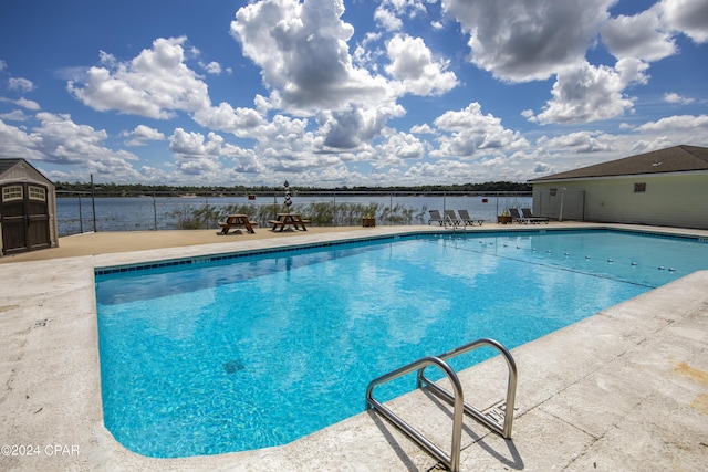 view of swimming pool featuring a patio area and a water view