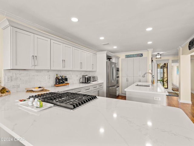 kitchen featuring light hardwood / wood-style flooring, light stone counters, a center island, sink, and appliances with stainless steel finishes