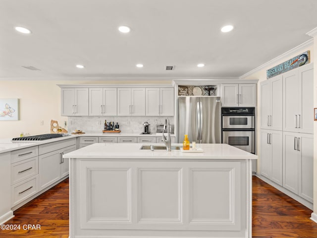 kitchen with a center island with sink, stainless steel appliances, ornamental molding, and dark hardwood / wood-style floors