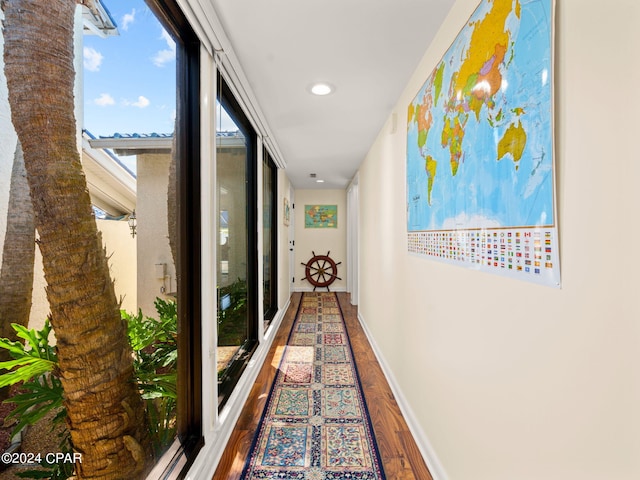 hall with wood-type flooring and floor to ceiling windows