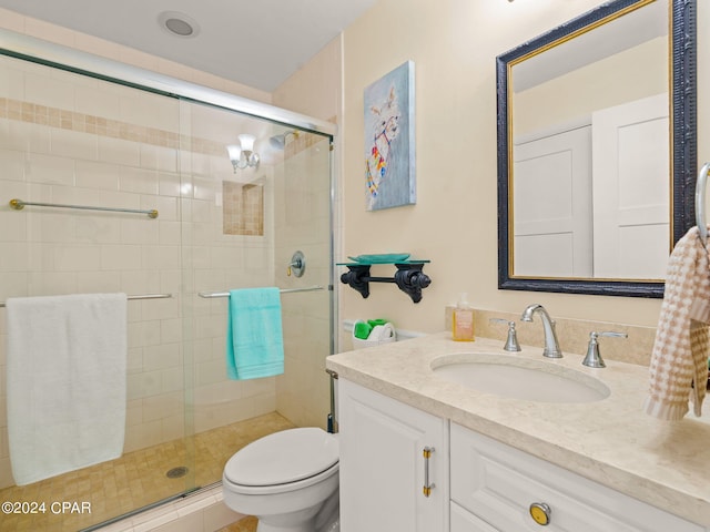 bathroom with vanity, toilet, and a shower with shower door