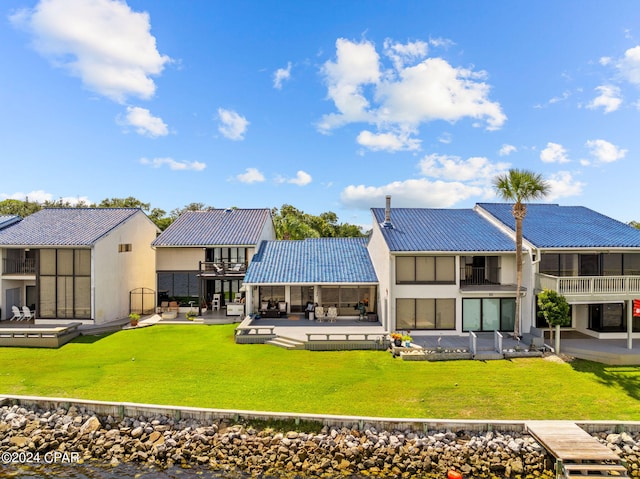 back of house with a lawn, a patio area, a pool, and a balcony