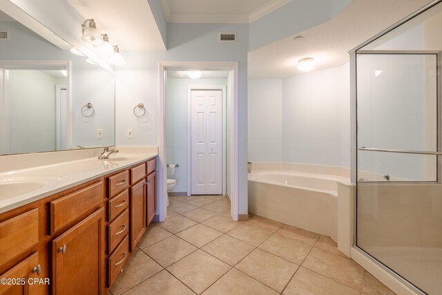 bathroom featuring tile patterned flooring, toilet, crown molding, vanity, and a bathing tub