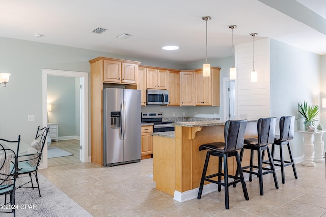 kitchen with light brown cabinets, light stone countertops, and appliances with stainless steel finishes