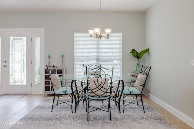 dining space featuring a chandelier, light tile patterned flooring, baseboards, and a healthy amount of sunlight