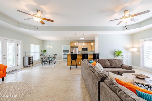 kitchen with stainless steel appliances, hanging light fixtures, sink, and light stone counters