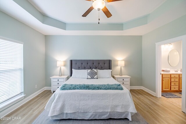 tiled living room featuring a tray ceiling and ceiling fan with notable chandelier