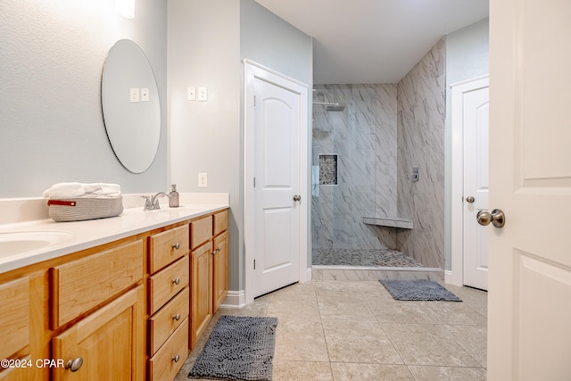 bathroom featuring a sink, double vanity, a marble finish shower, and tile patterned floors