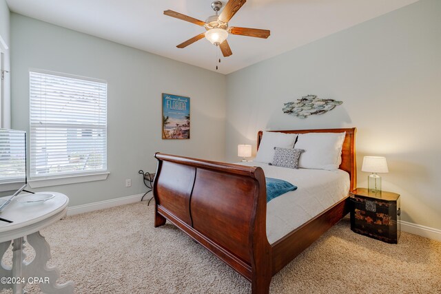 bedroom with connected bathroom, a tray ceiling, and ceiling fan