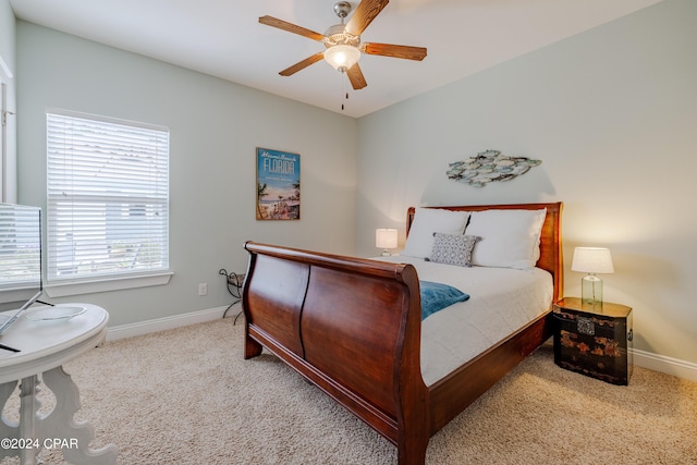 bedroom with light carpet, a ceiling fan, and baseboards