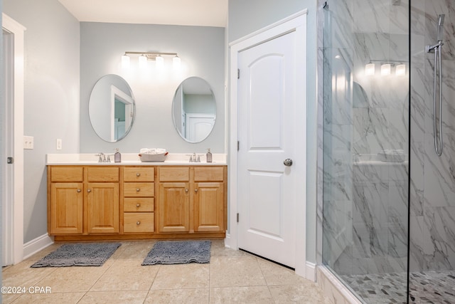 bathroom with a tile shower, vanity, and tile patterned floors