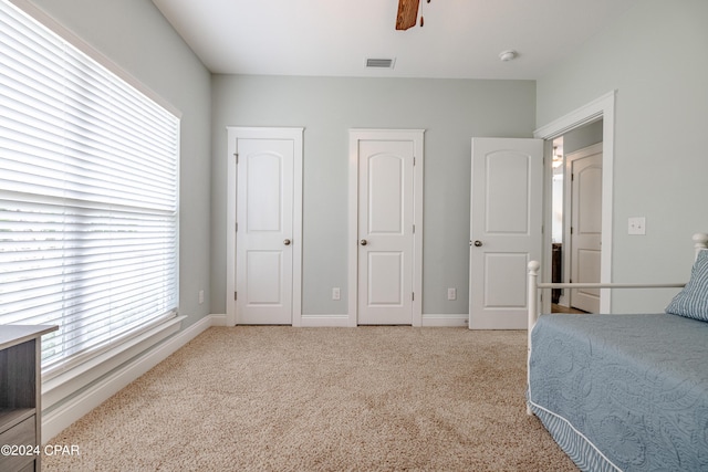 bedroom with light carpet, visible vents, and baseboards