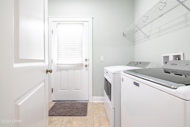 laundry room with light tile patterned floors, laundry area, and separate washer and dryer