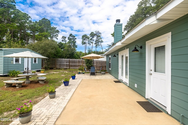 view of patio / terrace featuring an outbuilding, outdoor dining space, and fence