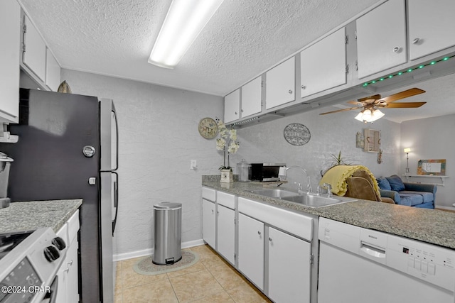 kitchen with a textured ceiling, appliances with stainless steel finishes, sink, and white cabinets