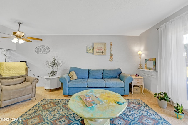 living room with light tile patterned flooring, ceiling fan, and ornamental molding