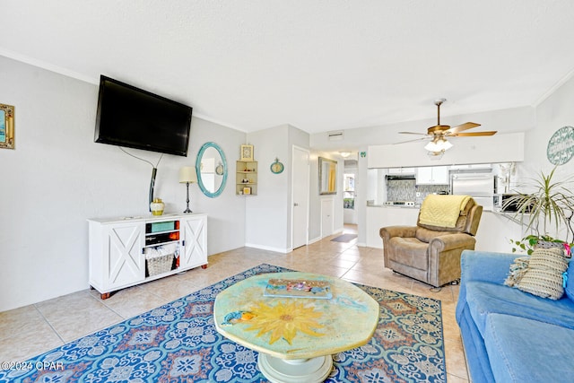 tiled living room with ceiling fan and crown molding