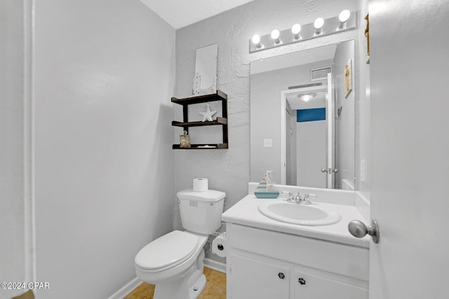 bathroom featuring tile patterned flooring, vanity, a textured ceiling, and toilet