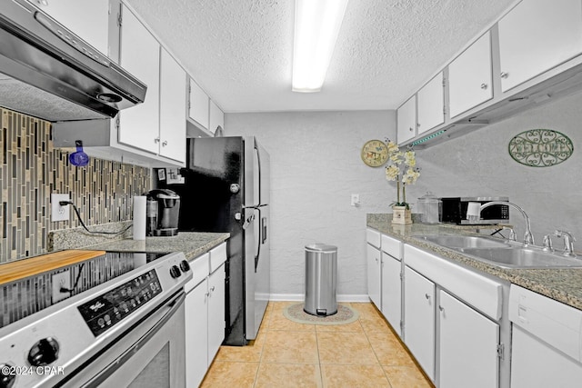 kitchen with stainless steel appliances, sink, tasteful backsplash, light tile patterned floors, and white cabinets