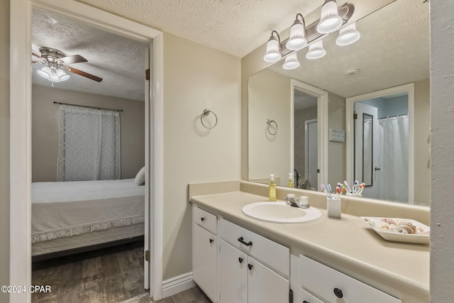 bathroom featuring wood-type flooring, ceiling fan, a textured ceiling, and vanity