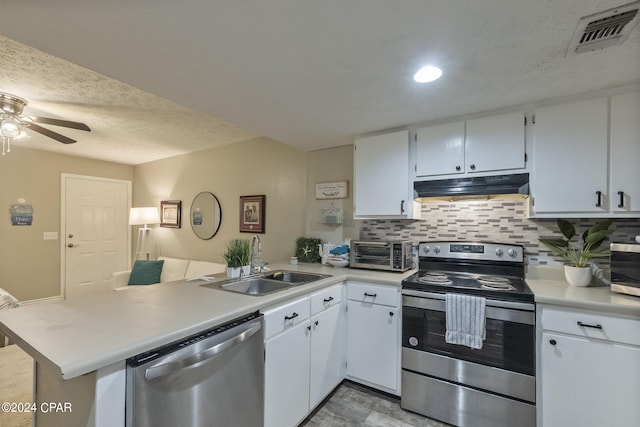 kitchen with appliances with stainless steel finishes, white cabinetry, sink, kitchen peninsula, and ceiling fan