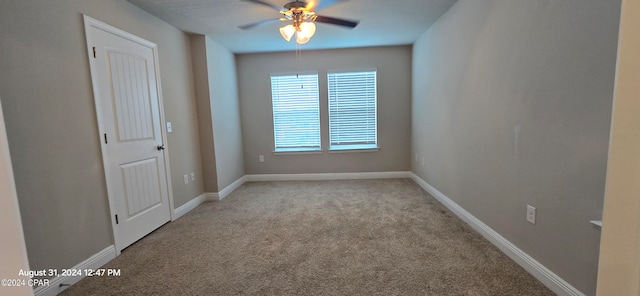 carpeted spare room with ceiling fan