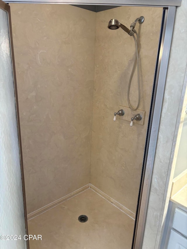 bathroom featuring walk in shower and vanity