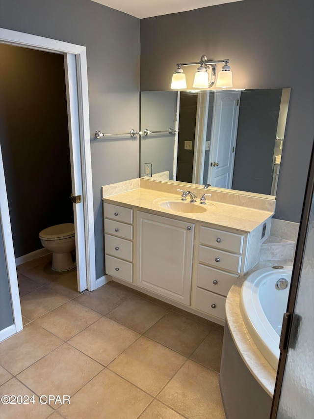 bathroom with vanity, tile patterned flooring, toilet, and a bath