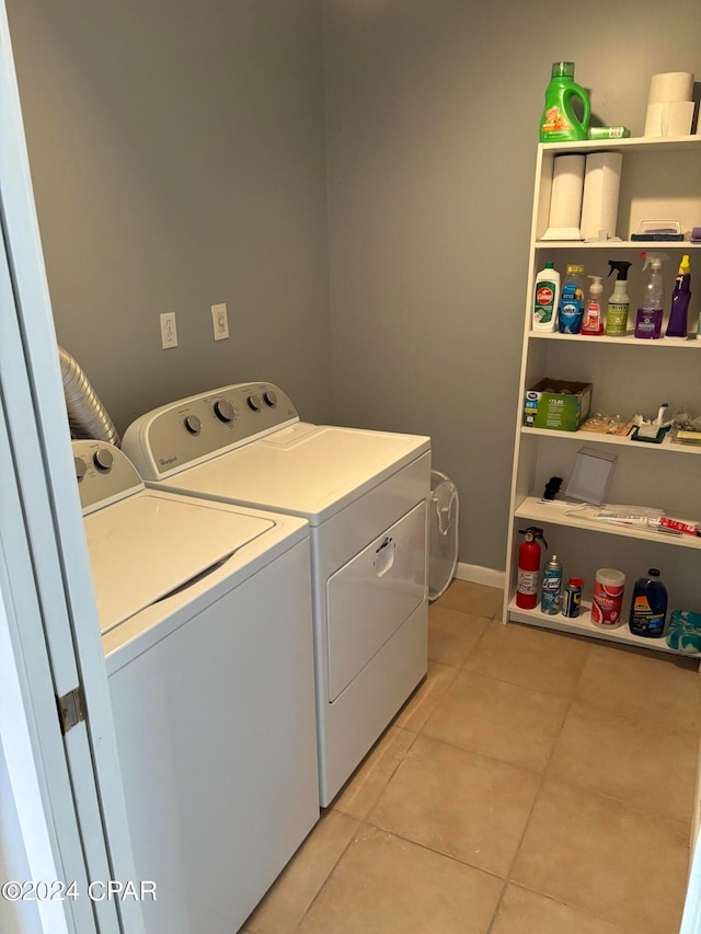 laundry room with light tile patterned flooring and washing machine and clothes dryer