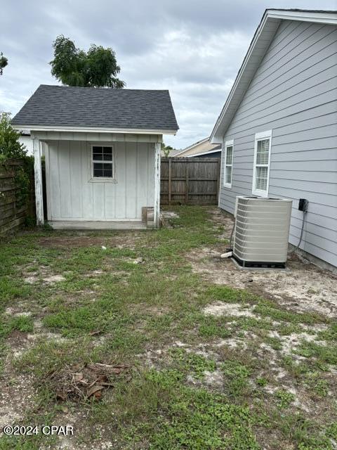 view of yard with a storage unit and central air condition unit