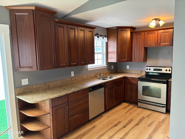 kitchen featuring light stone countertops, light wood-type flooring, appliances with stainless steel finishes, and sink