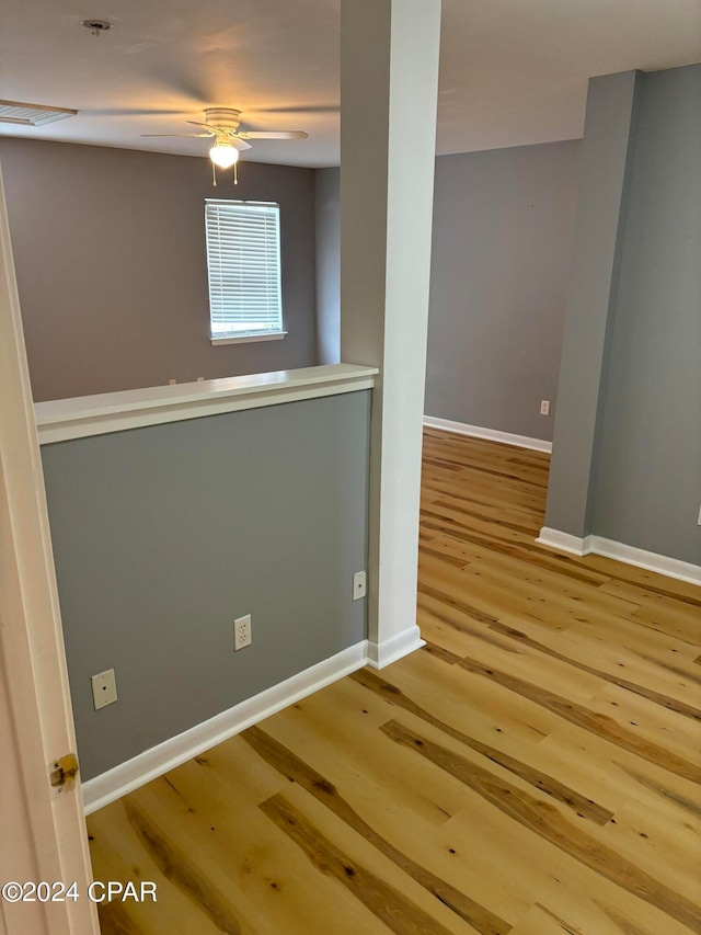 empty room with ceiling fan and hardwood / wood-style flooring