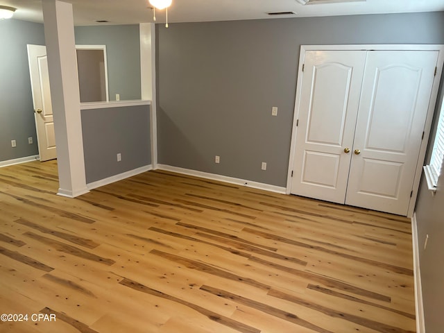 unfurnished bedroom with light hardwood / wood-style floors and a closet