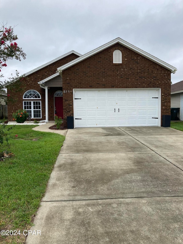 single story home featuring a garage and a front yard