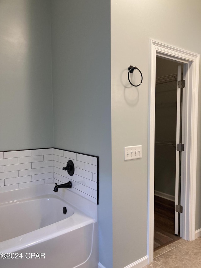 full bath with a garden tub and baseboards