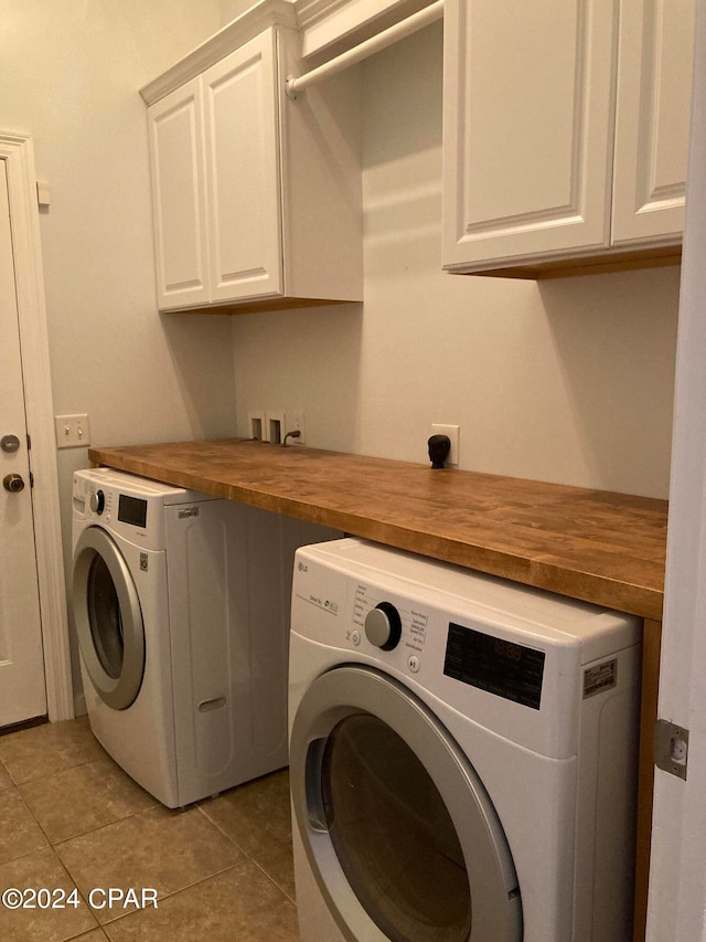 washroom with cabinets, washer and dryer, and light tile patterned floors