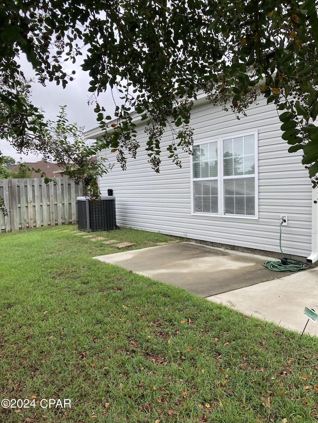 view of yard with a patio, central AC unit, and fence