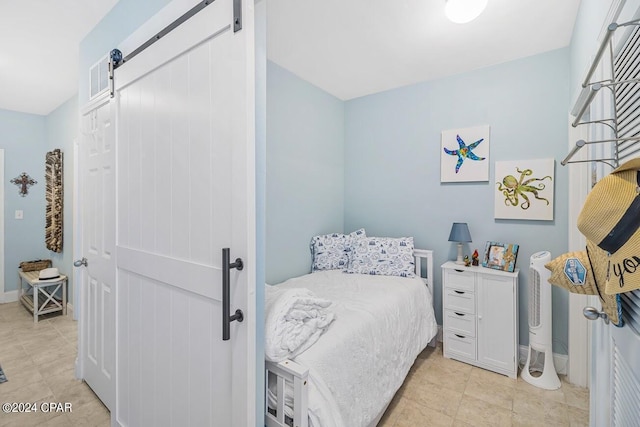 bedroom featuring a barn door and baseboards