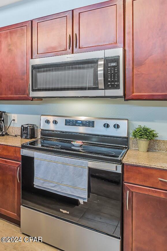 kitchen featuring appliances with stainless steel finishes, light countertops, dark brown cabinets, and light tile patterned flooring